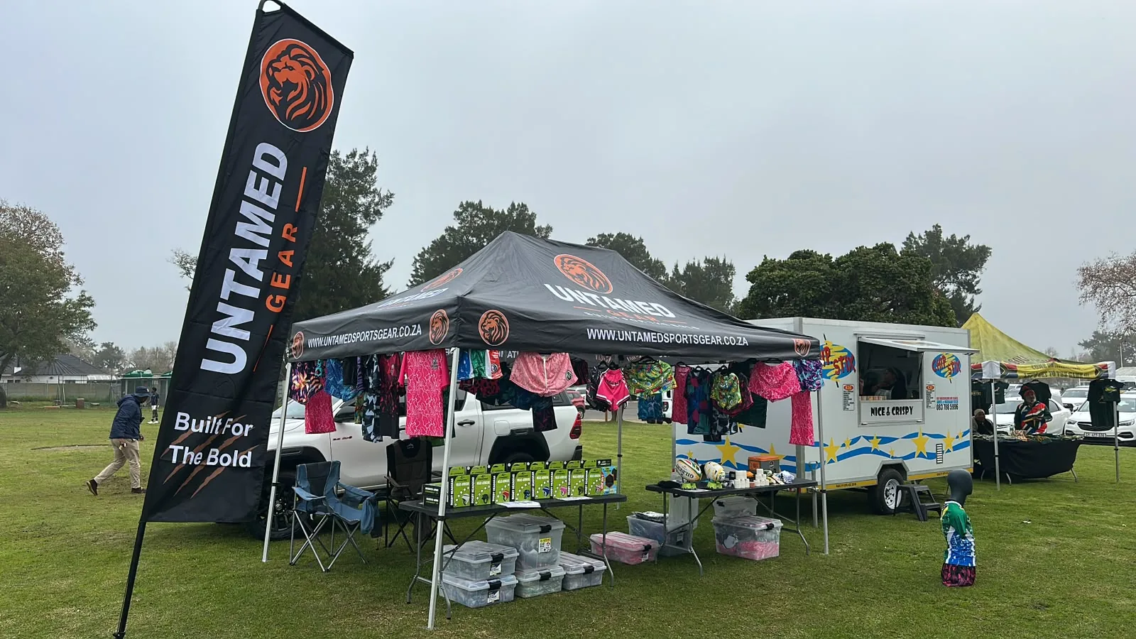 Untamed Gear branded event stall with rugby shirts and rugby shorts on display at a South African sports event