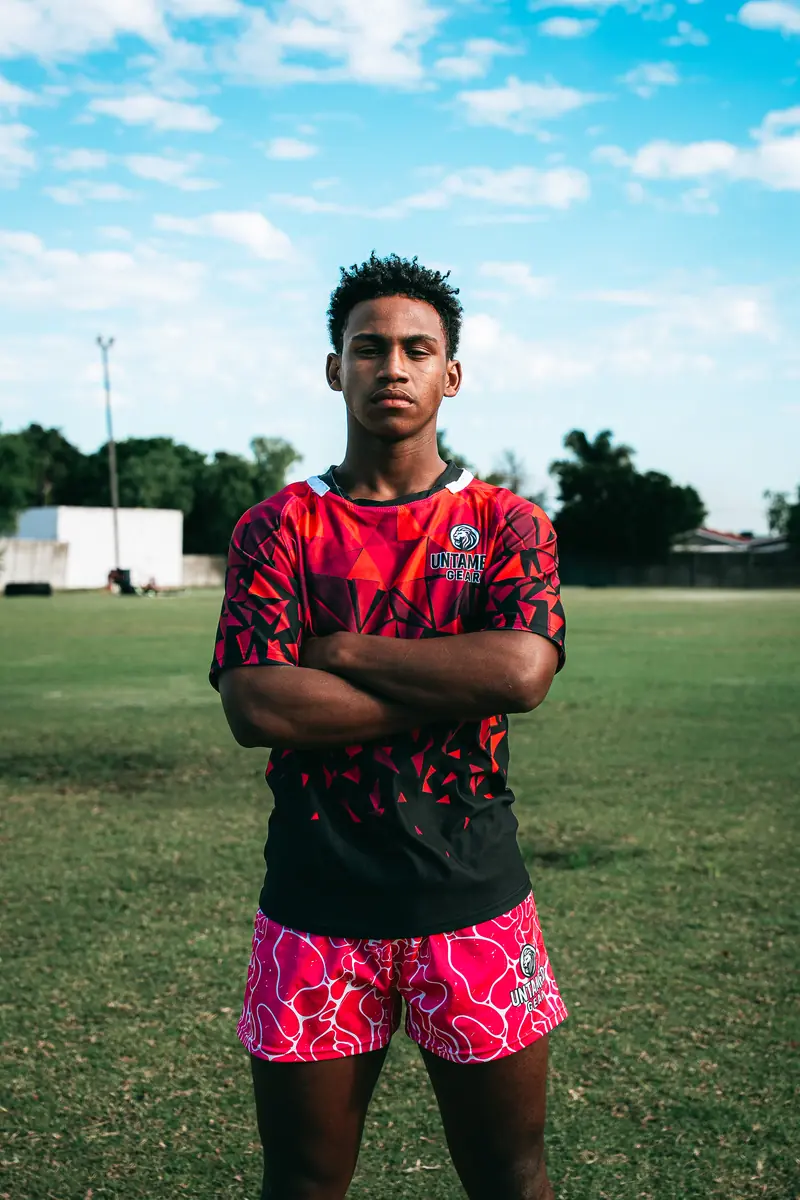 Untamed Gear athlete in red geometric rugby shirt, arms crossed